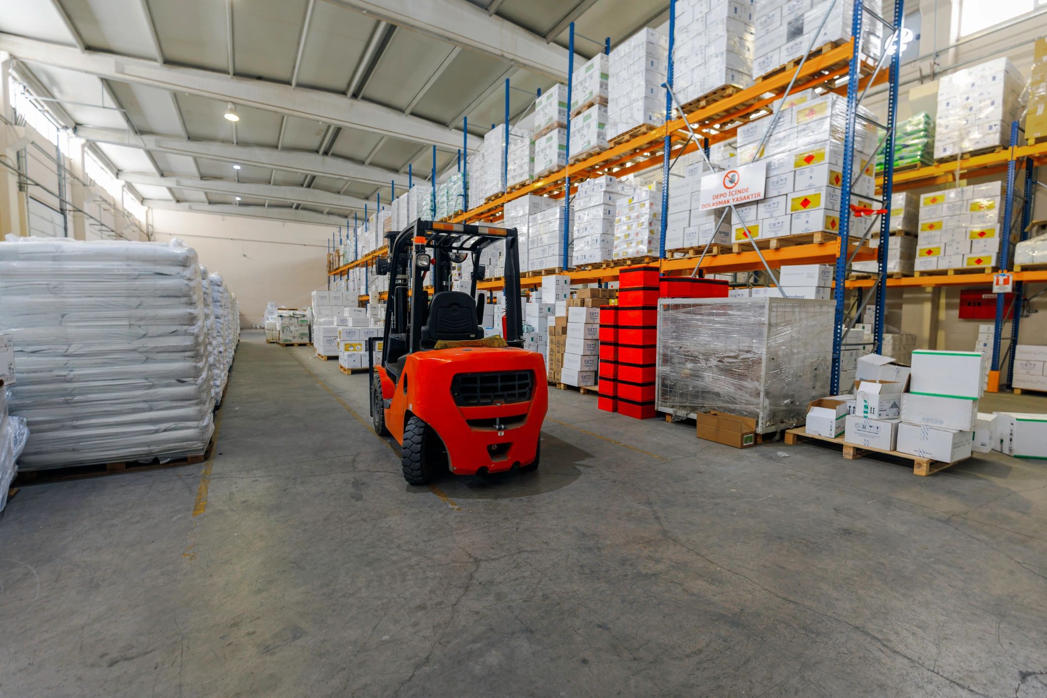 Warehouse aisle with forklift and palletized goods